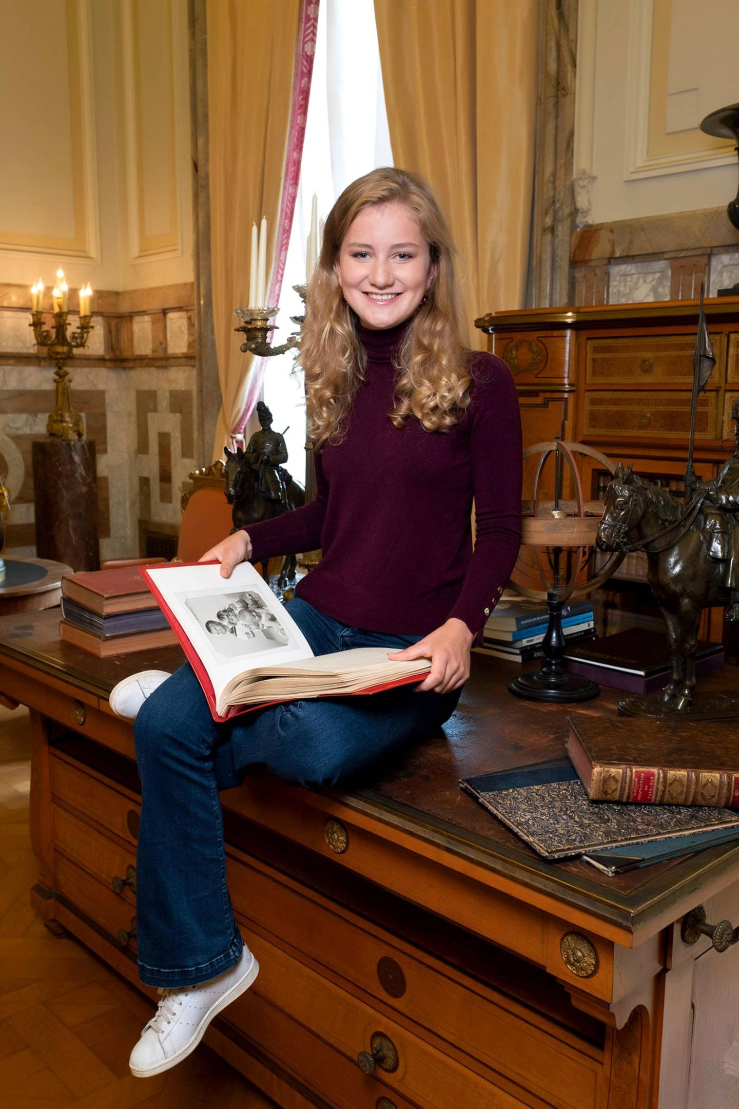 23. Oktober 2019  Fröhlich lächelt die belgische Kronprinzessin beim Betrachten eines Familienalbums in die Kamera des Fotografen.