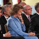 Königin Mathilde ist sichtlich gerührt und wischt sich eine kleine Träne von der Wange.