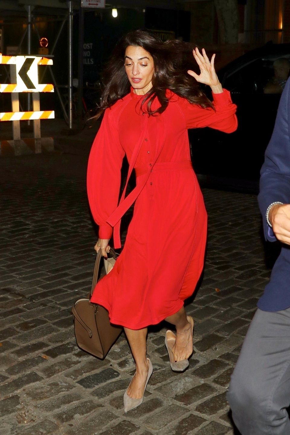 Manchmal wird auch einer High-Heel-erprobten Amal Clooney das Kopfsteinpflaster zum Verhängnis: Sie stolpert in ihren beigefarbenen Jimmy Choo Pumps und kann sich gerade noch so abfangen – und somit ein schlimmeres Malheur verhindern. Doch auch mit Stolpler sieht Amal in ihrem roten Burberry-Kleid einfach hinreißend aus. 