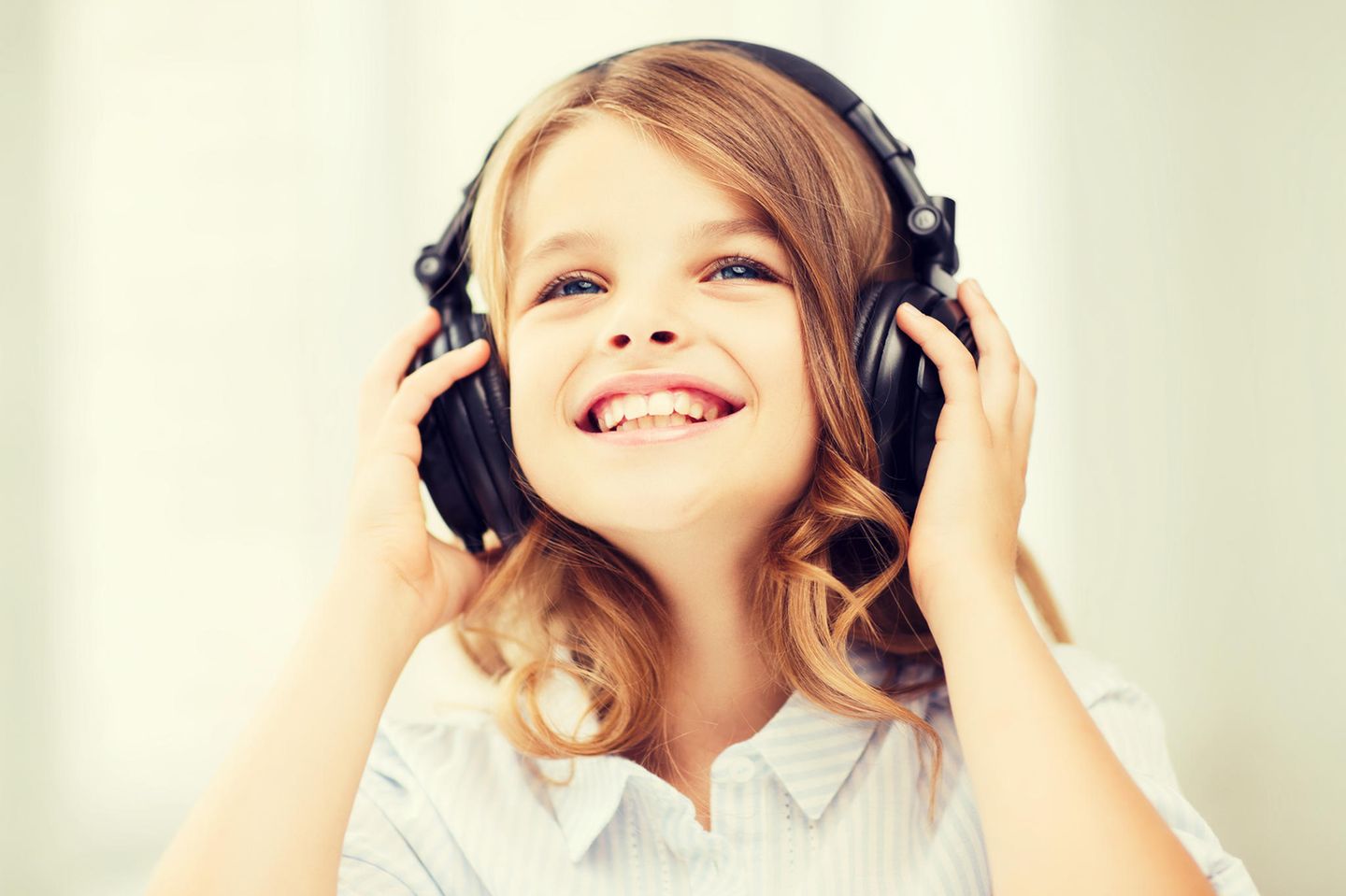 Kleines Mädchen hat Kopfhörer auf, Kopfhörer für Kinder, Kinder-Kopfhörer