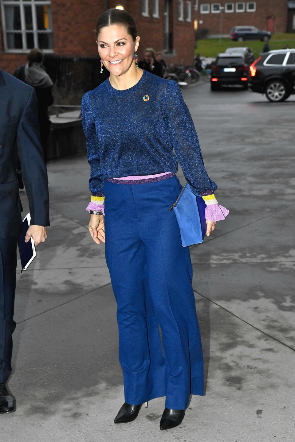 Sogar die Clutch von Kronprinzessin Victoria ist farblich zu ihrem restlichen Outfit abgestimmt. Einziger Farbtupfer stellen ihre langen Ohrringe mit bunten Steinchen dar. Obwohl sich die Blautöne farblich unterscheiden, wirkt ihr Outfit durch die Verwendung mehrerer Materialien stimmig. Sogar die Clutch von Kronprinzessin Victoria ist farblich zu ihrem restlichen Outfit abgestimmt. Einziger Farbtupfer stellen ihre langen Ohrringe mit bunten Steinchen dar. Obwohl sich die Blautöne farblich unterscheiden, wirkt ihr Outfit durch die Verwendung mehrerer Materialien stimmig.