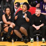 Sängerin Lizzo schaut sich in Los Angeles ein Spiel der Lakers an. In einem schwarzen, von vorne schlicht aussehenden, Kleid, Netzstrumpfhose und schwarzen Lack-Stiefeletten nimmt sie auf der Tribüne Platz. Jedoch nur für einen kurzen Moment... 
