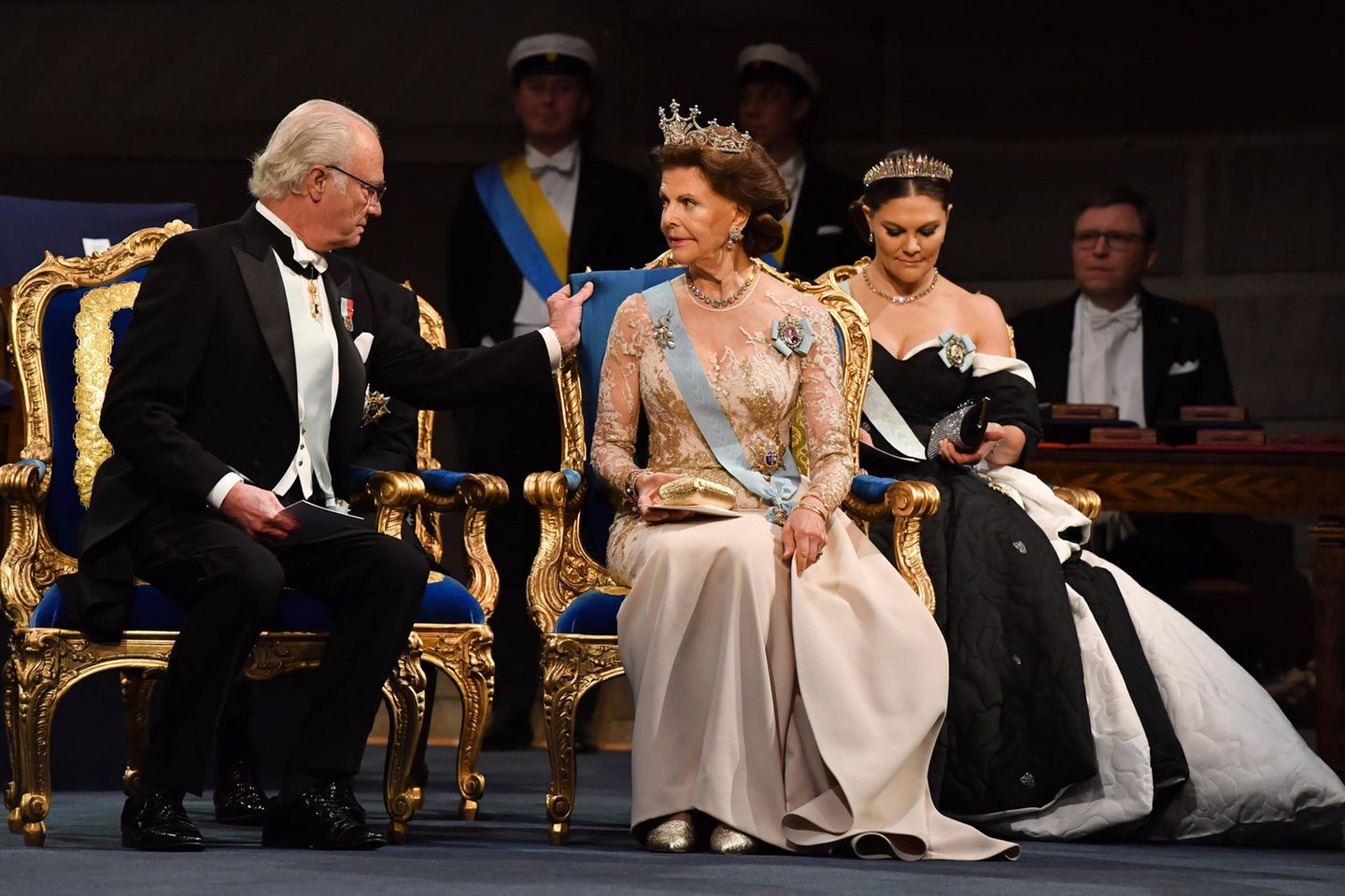 Royales Trio: König Carl Gustaf nimmt neben seiner Frau Königin Silvia und Kronprinzessin Victoria bei der Verleihung der Nobelpreise 2019 im Konzerthaus in Stockholm Platz. Den Dresscode "Herren in dunklen Anzügen und Krawatte, die Damen in einem Kleid" haben die schwedischen Royals souverän erfüllt. 