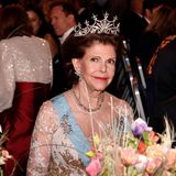 Es ist eines der beliebtesten Diademe von Königin Silvia von Schweden: Das Nine Prong Diadem hat mehr als 500 Diamanten. Königin Josefinas Perlen und Rubinen Brosche sowie eine glamouröse Diamantenkette runden ihren Look ab. 