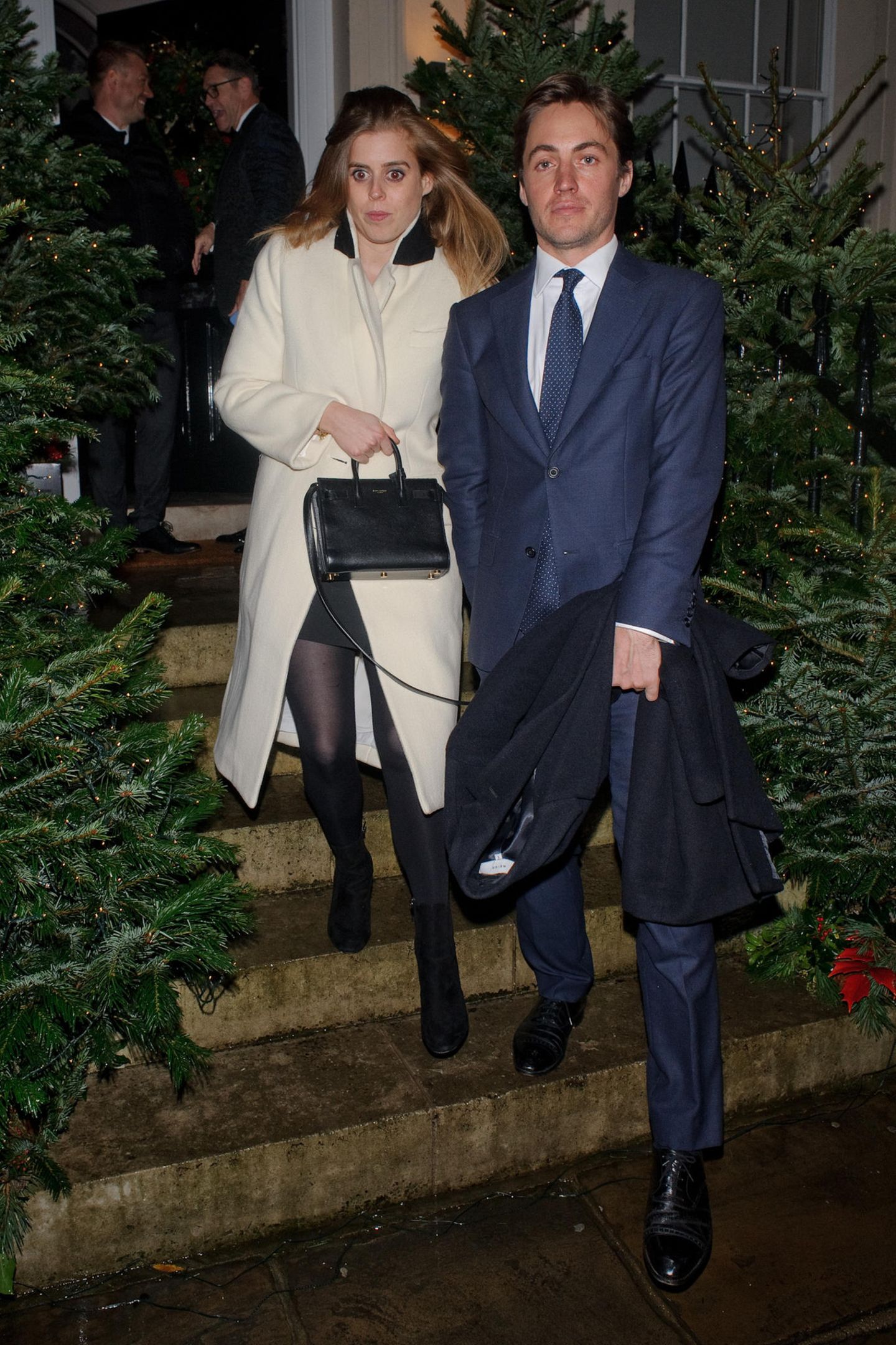 Mit leicht starrem Blick und auf wackeligen Beinen verlassen Prinzessin Beatrice und ihr Verlobter Edoardo die Weihnachtsfeier von Evgeny Lebedev, einem russisch-britischen Medien-Tycoon. Hand in Hand bahnen sich die beiden zu später Stunde den Weg zwischen den Tannenbäumen zum Auto. 