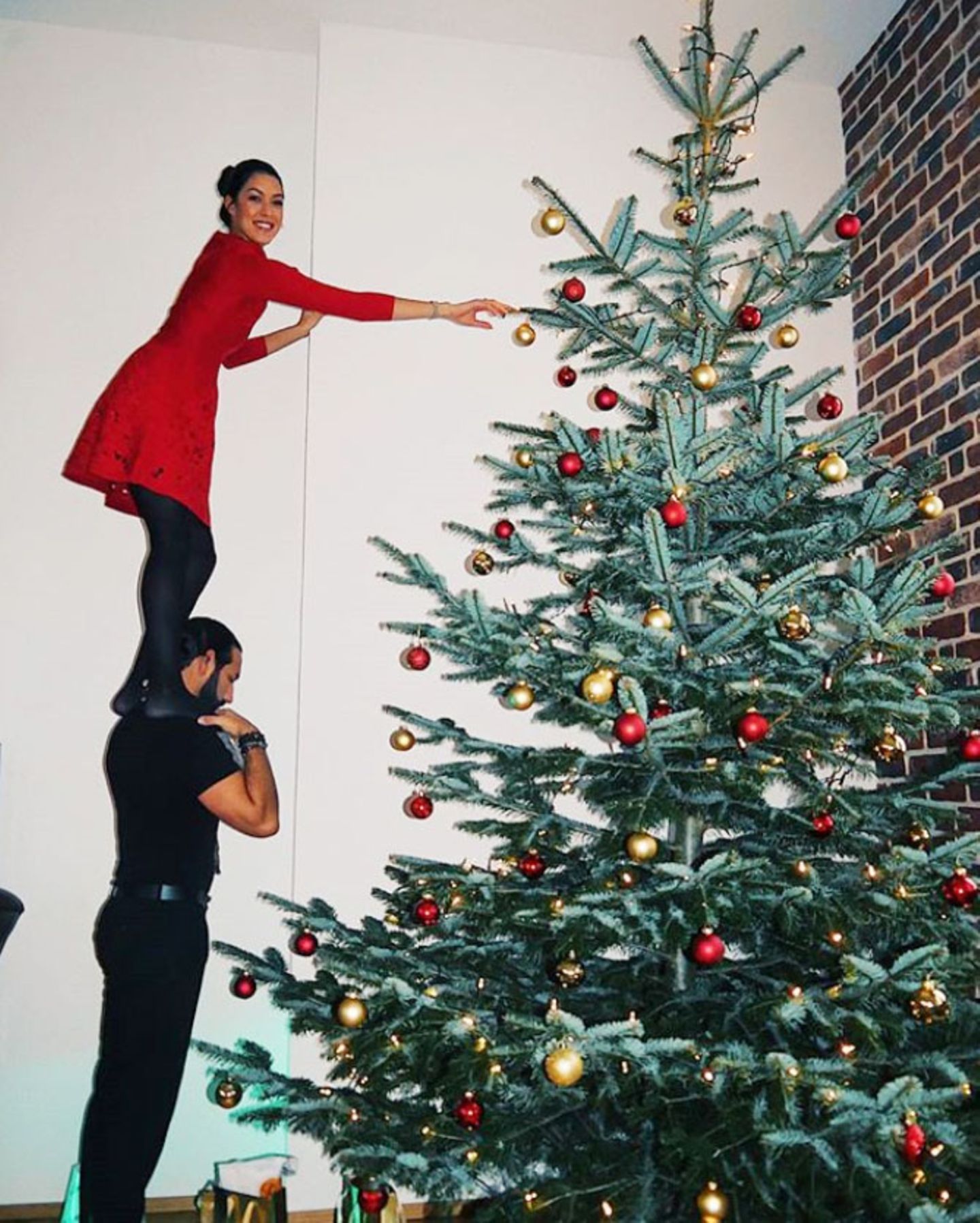 Schwindelfrei geht es für Rebecca Mir hoch hinauf zum Schmücken ihres riesigen Weihnachtsbaums. Auch auf den Schultern ihres Liebsten macht das Model eine gute (Weihnachts-)Figur.