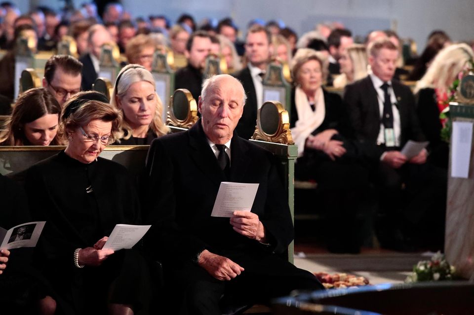 Das norwegische Königspaar Sonja und Harald und dahinter Prinzessin Mette-Marit mit ihrer Tochter Ingrid Alexandra stimmen ein Lied für Ari Behns letzten Weg ein.