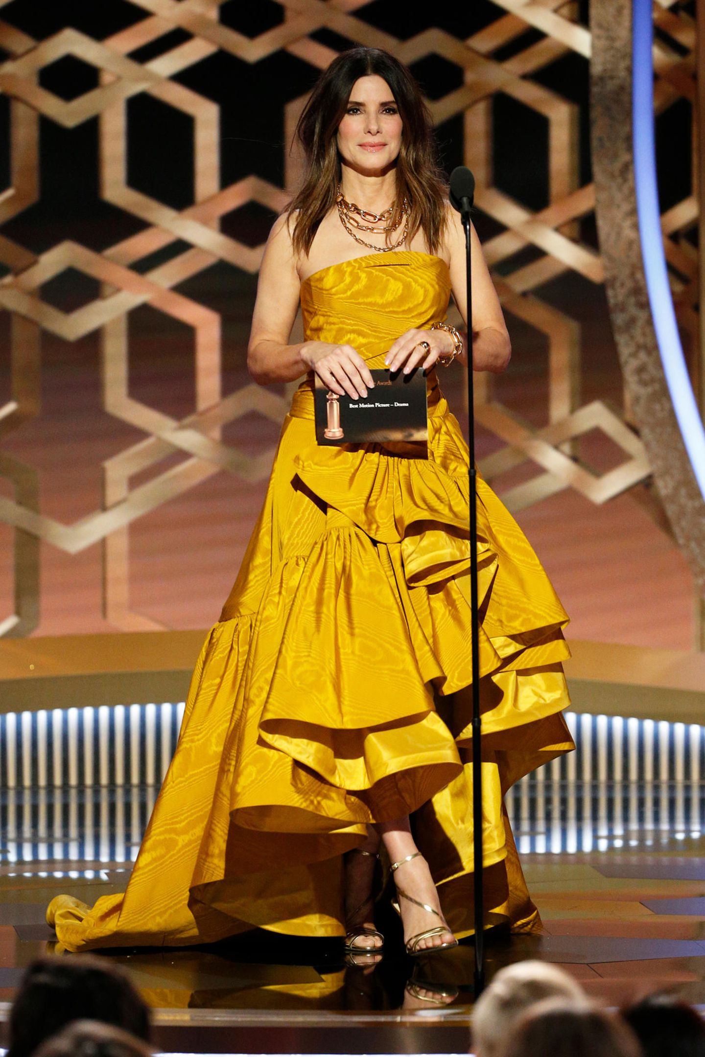 Sandra Bullock zeigt sich auf der Bühne im goldig changierenden, asymmetrischen Outfit.