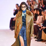Bereits im Februar 2019 präsentiert Kaia Gerber den braunen Designermantel auf dem Catwalk der Fashion Week in Paris. Der Look des Models ist für diesen Anlass betont dramatisch: So trägt Kaia eine XL-Sonnenbrille und Lederstiefel, als sie über den Laufsteg stolziert und sorgt mit dem schönen Braun-Blau-Kontrast für Begeisterung in der Front Row.
