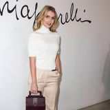 Lady Kitty Spencer erscheint zur Fashionshow von Schiaparelli in einem weißen Rollkragenpullover in Kombination mit einer weit geschnittenen Stoffhose. 