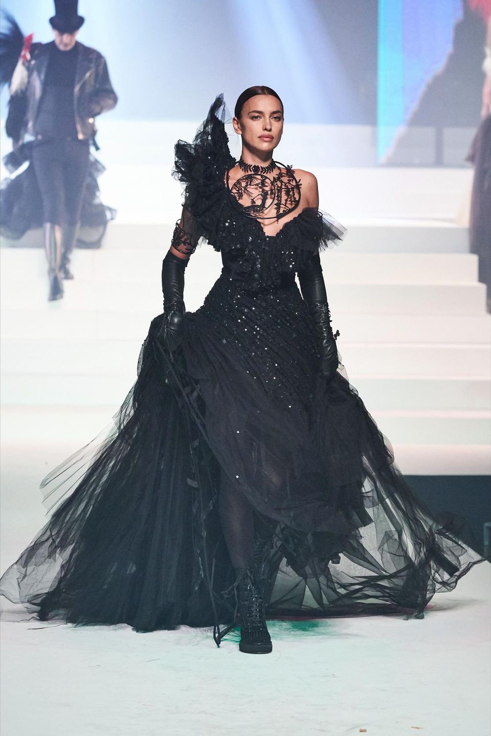 Während der Jean Paul Gaultier Haute Couture Show schreitet sie auch als Model in einer schwarzen Wow-Robe über den Laufsteg. 