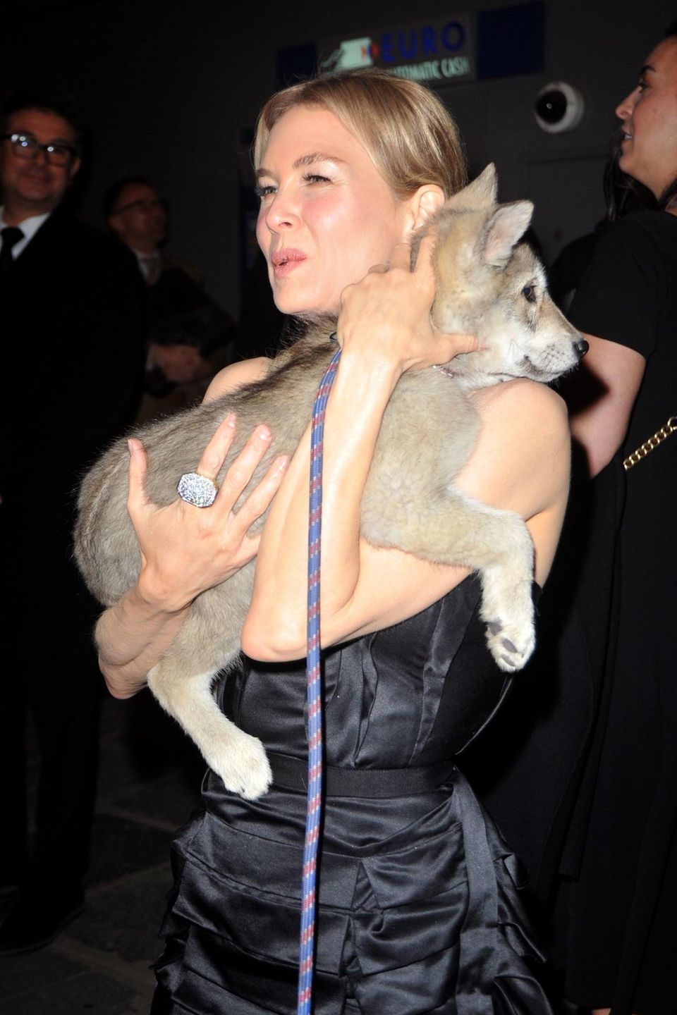 Renee Zellweger trägt einen Hundewelpen auf dem Arm