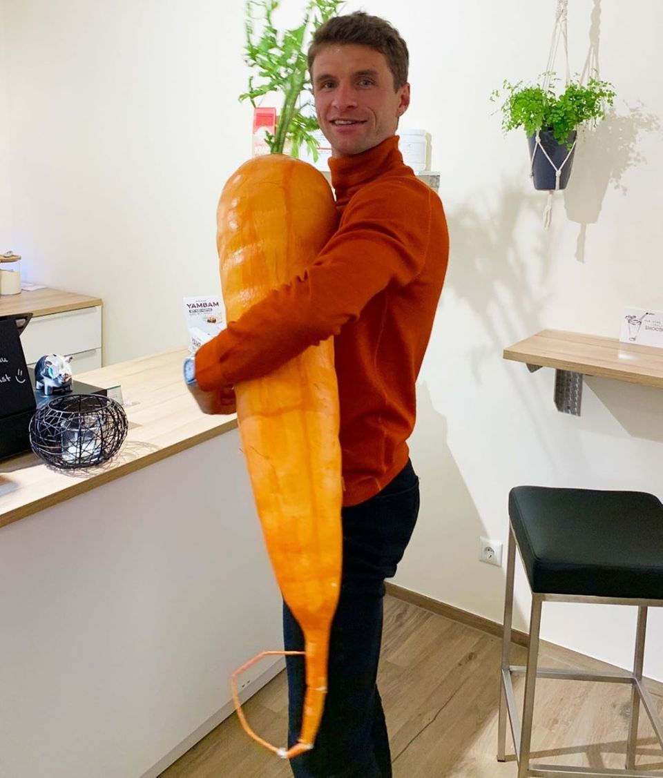 Thomas Müller hält eine riesige Plastik-Karotte Thomas Müller hält eine riesige Plastik-Karotte