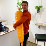 Thomas Müller hält eine riesige Plastik-Karotte