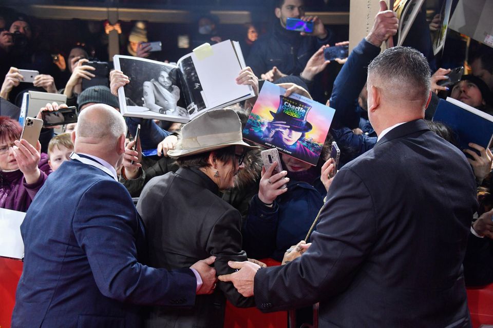 Johnny Depp hat alle Hände voll zu tun, seinen treuen Fans gerecht zu werden. Fleißig gibt er Autogramme.