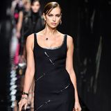 Irina Shayk tigert im eng anliegenden schwarzen Kleid den Versace-Catwalk hinunter. 