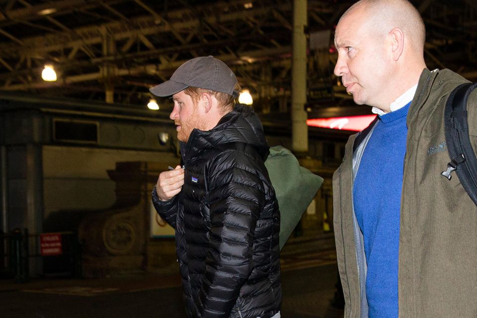 Herzogin Meghan + Prinz Harry: Begleitete von Sicherheitspersonal geht Prinz Harry zum Wagen Begleitete von Sicherheitspersonal geht Prinz Harry zum Wagen