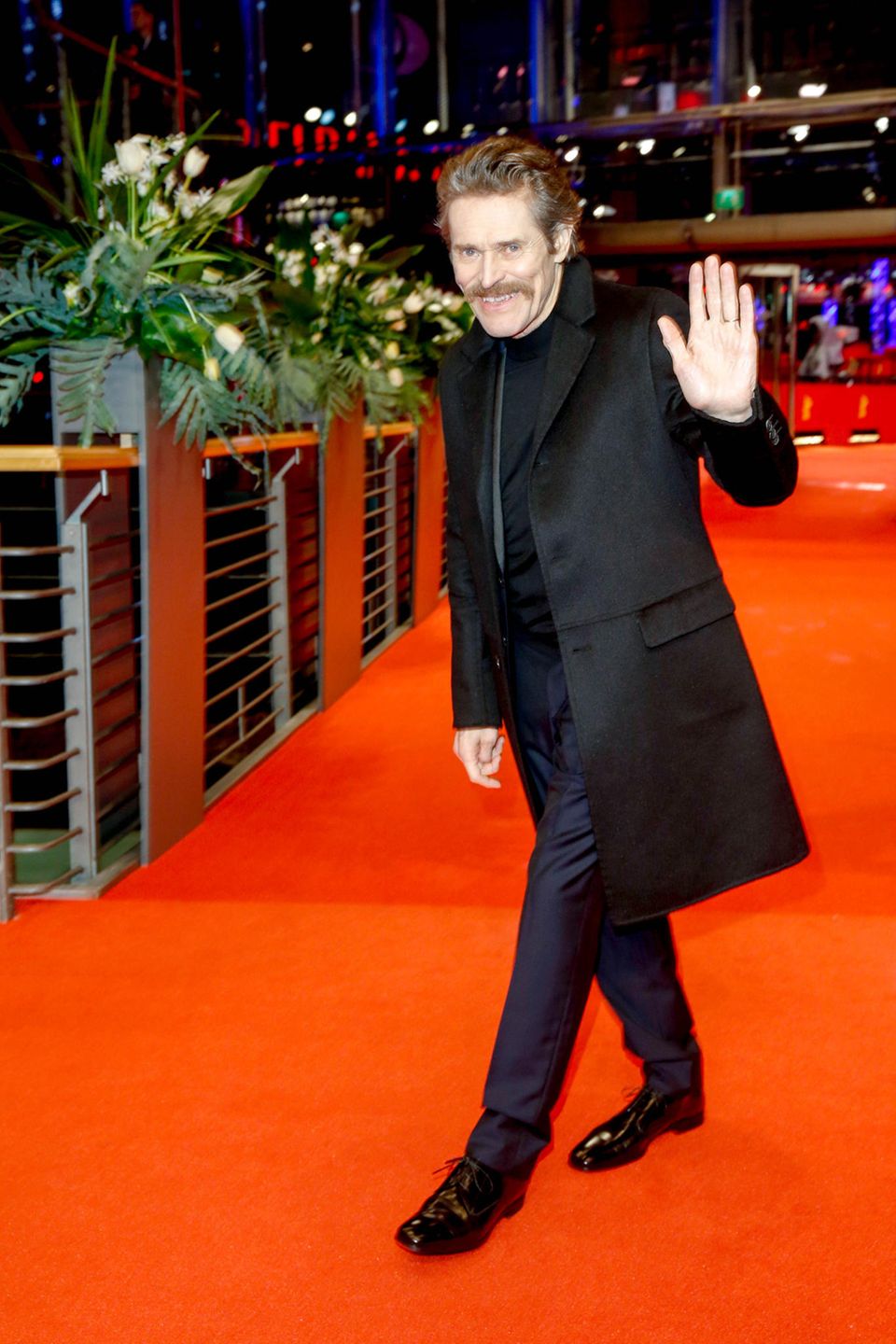 Willem Dafoe winkt auf dem roten Teppich der Berlinale