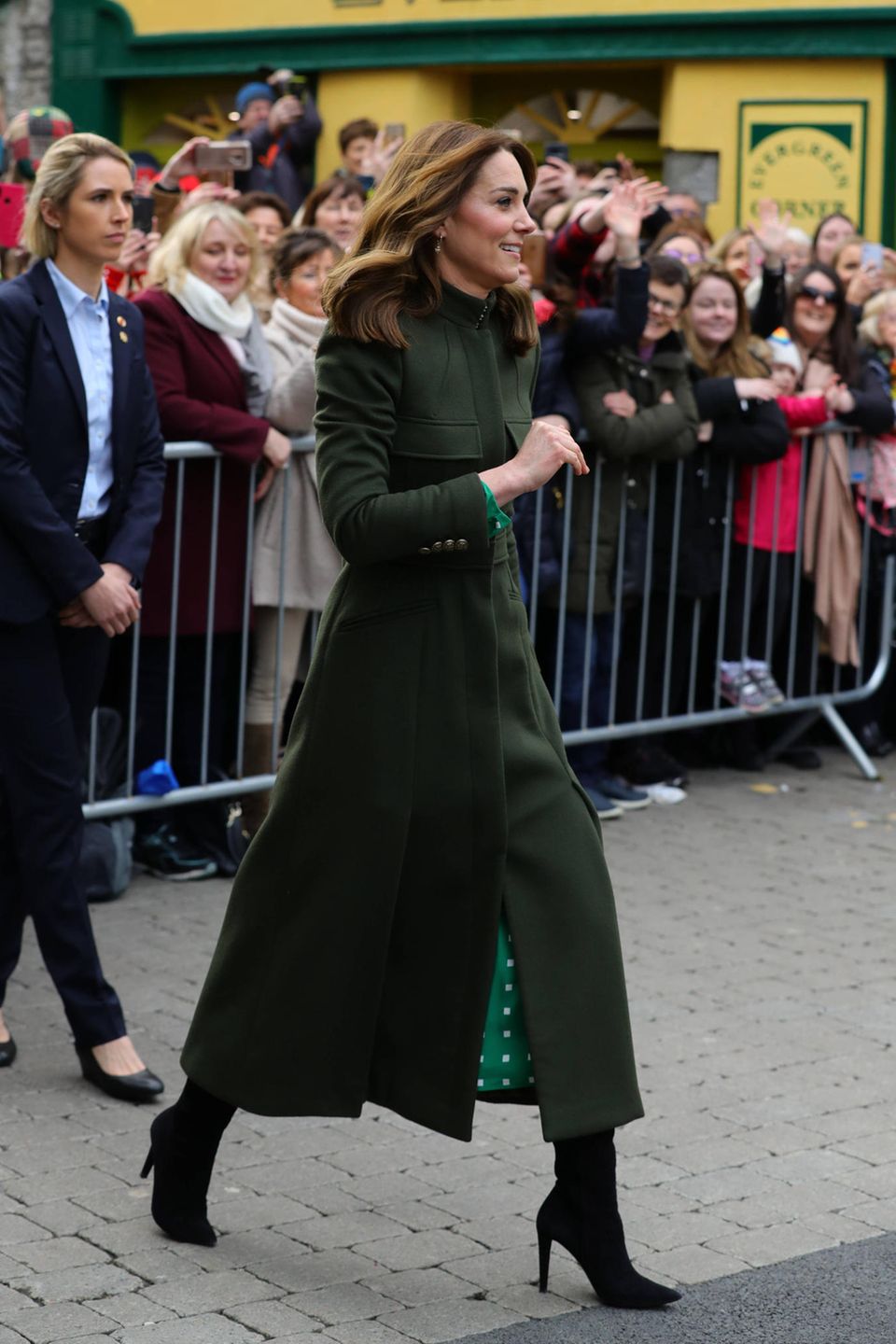 Draußen zieht sie dann einen dunkelgrünen Mantel von Alexander McQueen darüber, der zu den schwarzen Stiefeln von Ralph Lauren ebenfalls perfekt passt. 