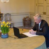 Bei König Philippe von Belgien ist schon der Frühling eingezogen. Er sitzt für eine Skype-Konferenz an einem großen Tisch auf dem ein paar Osterglocken stehen. Helle Möbel, ein schöner Korb und der orange Marker sind zusätzliche Hingucker! 