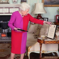 Her Royal Majesty, the Colour-blocking Queen! Elizabeth II. zeigt sich inmitten der Coronakrise besonders mutig und trägt ein pink-rotes Etuikleid zur typischen Perlenkette.
