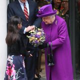 Lila, der (noch lange nicht) letzte Versuch: Queen Elizabeth nimmt in leuchtendem Violett einen Blumenstrauß beim Besuch eines Londoner Krankenhauses entgegen.