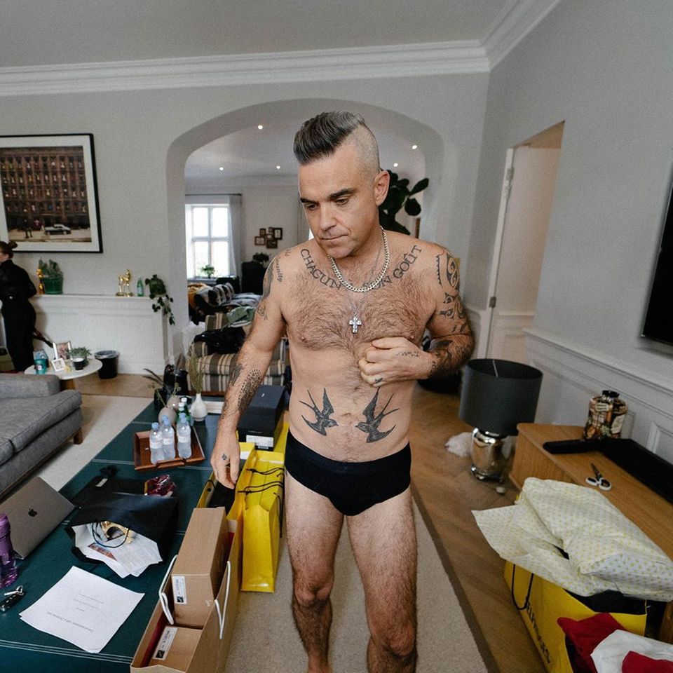 Vom Popstar zum Rockstar? Robbie Williams scheint sich ein wenig wie auf Tournee zu fühlen. Oben ohne und lediglich in Boxershorts liegt der Fokus zwar auf seinem durchtrainierten Körper, doch in seinem Wohnzimmer scheint passend zum Rockstar-Leben auch das Chaos ausgebrochen zu sein .... Was wohl seine Frau Ayda dazu sagt? Vom Popstar zum Rockstar? Robbie Williams scheint sich ein wenig wie auf Tournee zu fühlen. Oben ohne und lediglich in Boxershorts liegt der Fokus zwar auf seinem durchtrainierten Körper, doch in seinem Wohnzimmer scheint passend zum Rockstar-Leben auch das Chaos ausgebrochen zu sein .... Was wohl seine Frau Ayda dazu sagt?