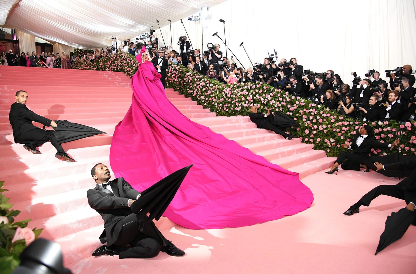 2019  Lady Gaga zeigte sich mit ihrem inszenierten Riesentraum in Pink als überaus wandelbar. Am Ende des roten Teppich war der Stoffberg einem Glitzer-Bikini und Netzstrümpfen gewichen.