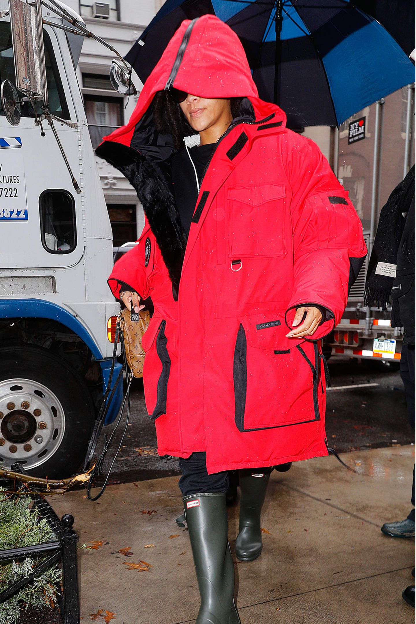 Wer versteckt sich denn hier unter seiner XXL-Daunenjacke in Knallrot? Sängerin Rihanna ist mit ihrem Look vor Wind und Wetter geschützt. 