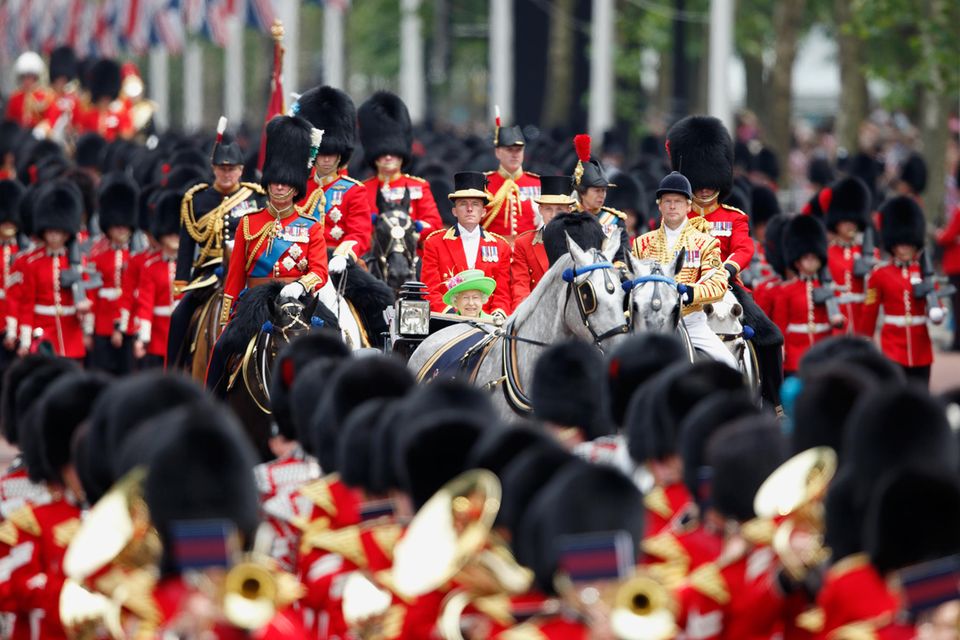 2016 ist die Queen vor lauter Soldaten in ihrer Kutsche kaum zu erkennen. Gut, dass zumindest ihr neongrüner Hut hervorblitzt. Was für ein Spektakel! 