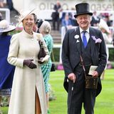 Prinzessin Anne strahlt an der Seite von Andrew Parker-Bowles, dem Ex-Mann von Herzogin Camilla. Sie wählt einen zartgelben Mantel, unter dem ein hellbrauner Rock zu sehen ist. Auch sie stimmt ihre Kopfbedeckung auf den Rest des Looks ab. 