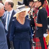 Beim Empfang von Emmanuel Macron in London zeigte sich Herzogin Camilla von ihrer elegantesten Seite: Ein dunkelblaues Spitzenkleid kombiniert sie zu Hut, Perlenkette, Lederhandschuhen und Chanel-Pumps. Très chic!