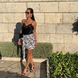 Ana Ivanovic zeigt, wie elegantes Sommer-Styling geht: Schlichtes Top, gemusterter Rock, dazu auffällige Ohrringe und schwarze Schuhe, Tasche und Sonnenbrille - volle Punktzahl für diesen luftigen Look.