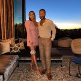 Für ein romantisches Date haben sich Chrissy Teigen und John Legend schick gemacht: Das Model trägt ein rosafarbenes Kleid mit tiefem V-Ausschnitt, kleinen Knöpfen und Puffärmeln, der Oscar-Preisträger setzt auf ein gepunktetes Hemd und eine helle Hose. 