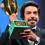 Der italienische Schauspieler Pierfrancesco Favino hält stolz seine Coppa Volpi in die Luft. Er wurde in diesem Jahr als bester Darsteller ausgezeichnet.