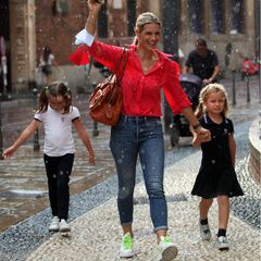 Vom Regen überrascht lassen sich Michelle Hunziker und ihre Töchter Celeste und Sole nicht die Stimmung verderben. Während Michelle farblich aus dem Muster fällt,  glänzen die beiden Schwestern in einem aufeinander abgestimmten Look. Beide Mädchen tragen die Haare zu zwei Zöpfen gebunden, T-Shirts mit dem gleichen "SC"-Emblem und dazu einen dunkelblauen Rock und Hose. Die Outfits erinnern an eine Schul- oder Sportuniform und geben den modischen Minis einen sportlichen Touch. 