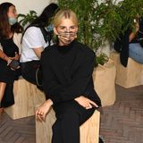 Das Accessoire des Jahres! Alle Zuschauer der Fashion Shows tragen Masken: So auch Caro Daur, die zu ihrem komplett schwarzen Look eine Maske mit animalischem Print wählt. 