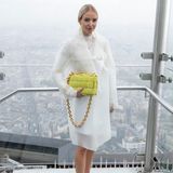 Die deutsche Mode-Bloggerin Leonie Hanne posiert in schwindelerregender Höhe für die Fotografen bei der Show von Coperni. Ein minimalistischer Regenmantel und neongrüne Accessoires von Bottega Veneta machen ihren Look perfekt. 