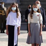Obwohl Prinzessin Sofia und Prinzessin Leonor beide auf die Kombination 'Rock und Dreiviertelbluse in Weiß und Ballerina' setzen, könnten ihre Outfits unterschiedlicher nicht sein. Wie das geht? Während Prinzessin Sofia (li.) auf einen knöchellangen, gerade geschnittenen Rock mit schlichter Bluse mit Schleifendetails am unteren Saum setzt, entscheidet sich Prinzessin Leonor (re.) für einen knielangen Glockenrock, den sie mit einem weißen Pullover mit Puffärmeln kombiniert. Zwei Schwester, eine Fashion-Formel und dennoch zwei unterschiedliche Interpretationen. 