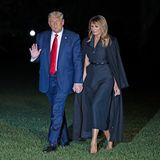 Melania Trump im schwarzen Tuxedo-Kleid und bodenlangem Mantel