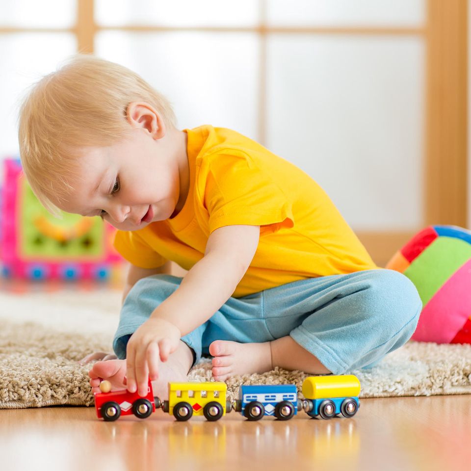 Kinderspielzeug, 2-Jähriger, Holzeisenbahn für Kinder, Junge spielt mit Holzbahn