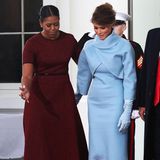 Michelle Obama zeigt ihr den Weg: Eine bildhafte Geste, denn Melania Trump tritt als 45. First Lady im Jahr 2017 in die Fußstapfen von Michelle. Ein geschichtsträchtiges Ereignis, bei dem die Looks der beiden Frauen unterschiedlicher nicht sein könnten. Während Michelle in einem warmen Rotton Melania in Empfang nimmt, setzt die Frau von Donald Trump auf ein Kleid in einem kühlen Hellblau. 