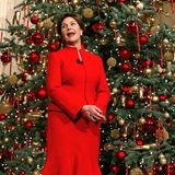 Passend zur Weihnachtszeit wählt Laura Bush einen Zweiteiler aus Blazer und Rock in der Knallfarbe Rot. Schlichte, schwarze Pumps runden den Look der First Lady ab. 