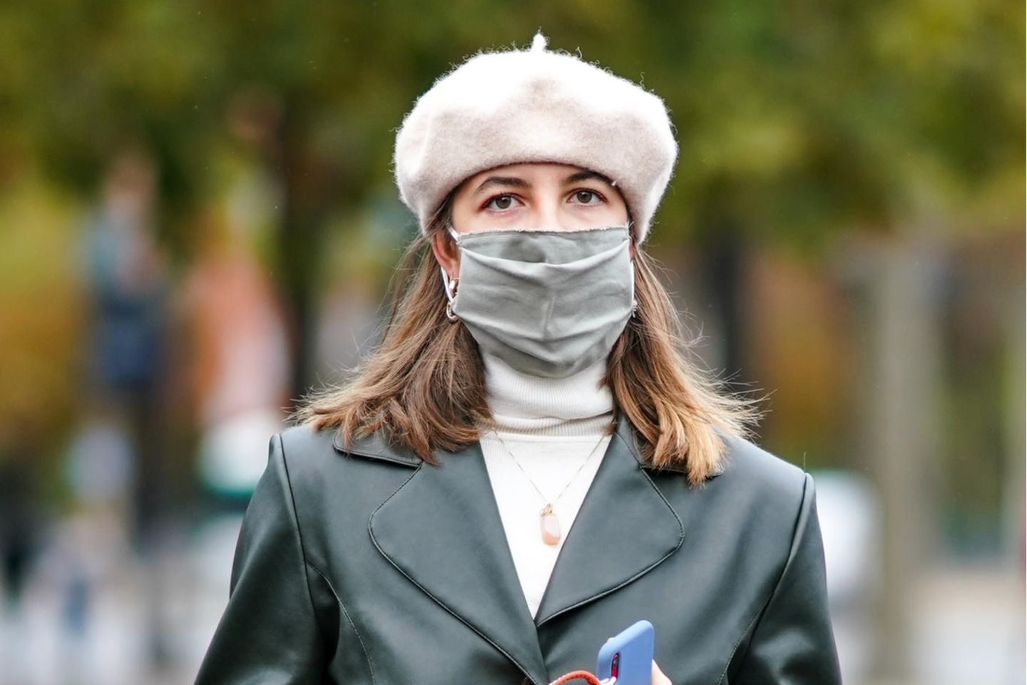 Fashionista mit Gesichtsmaske und Mütze vor der Chanel-Show