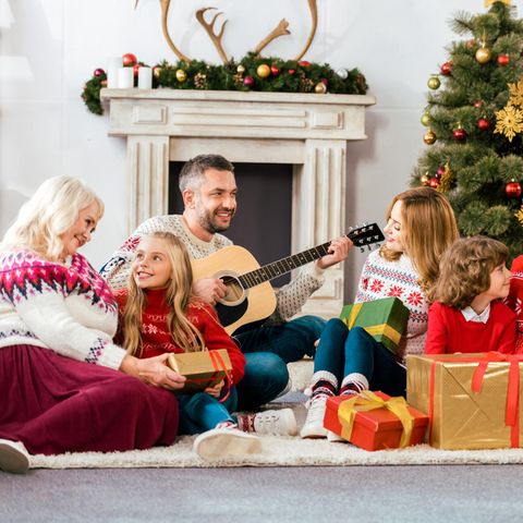 Weihnachten, Familie, Weihnachtspullover, Weihnachtsdeko, Geschenke, Vater mit Gitarre