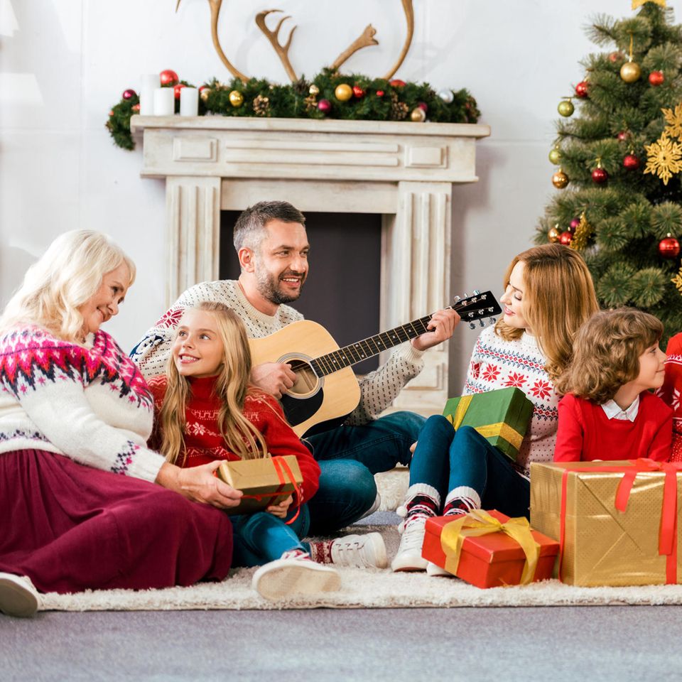 Weihnachten, Familie, Weihnachtspullover, Weihnachtsdeko, Geschenke, Vater mit Gitarre