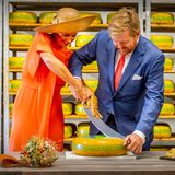 Zu zweit müssen Königin Máxima und König Willem-Alexander das Käse-Wiegemesser ergreifen, um sich bei ihrem Besuch in der Käserei "De Deelelen" im Örtchen Tijnje eine dicke Scheibe von dem glänzenden Laib abzuschneiden.
