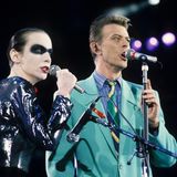 Mit dem Tod von Freddie Mercury im November 1991 konnte David Bowie eines der größten Duette der Musikgeschichte , "Under Pressure" nicht mehr "richtig" performen. Bei einem Konzert zu Ehren des verstorbenen Queen-Frontmanns im April 1992 übernimmt Annie Lennox dessen Part. Bowies Signature-Look der damaligen Jahre waren, wie hier, farbenfrohe Anzüge.