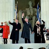 Am "Inauguration Day" im Jahr 1993 strahlt Hillary Clinton mit ihrem Ehemann und Präsidenten Bill Clinton um die Wette. Dabei trägt sie einen schwarzen weit geschnittenen Mantel. Besondere Akzente setzt sie mit ihrem Tuch, dessen Muster sich auch im Innenfutter und den Ärmeln der Jacke wiederfindet und ihr blondes Haar zum Leuchten bringt.