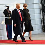 Ein historischer Moment: Donald Trump und Melania Trump verlassen das Weiße Haus. Für ihren letzten Auftritt als First Lady setzt Melania auf ein komplett schwarzes Outfit bestehend aus einer Chanel-Jacke mit seitlicher Knopfleiste und schienbeinlangem Kleid. Eine elegante Hochsteckfrisur rundet den "Trauer"-Look ab. 